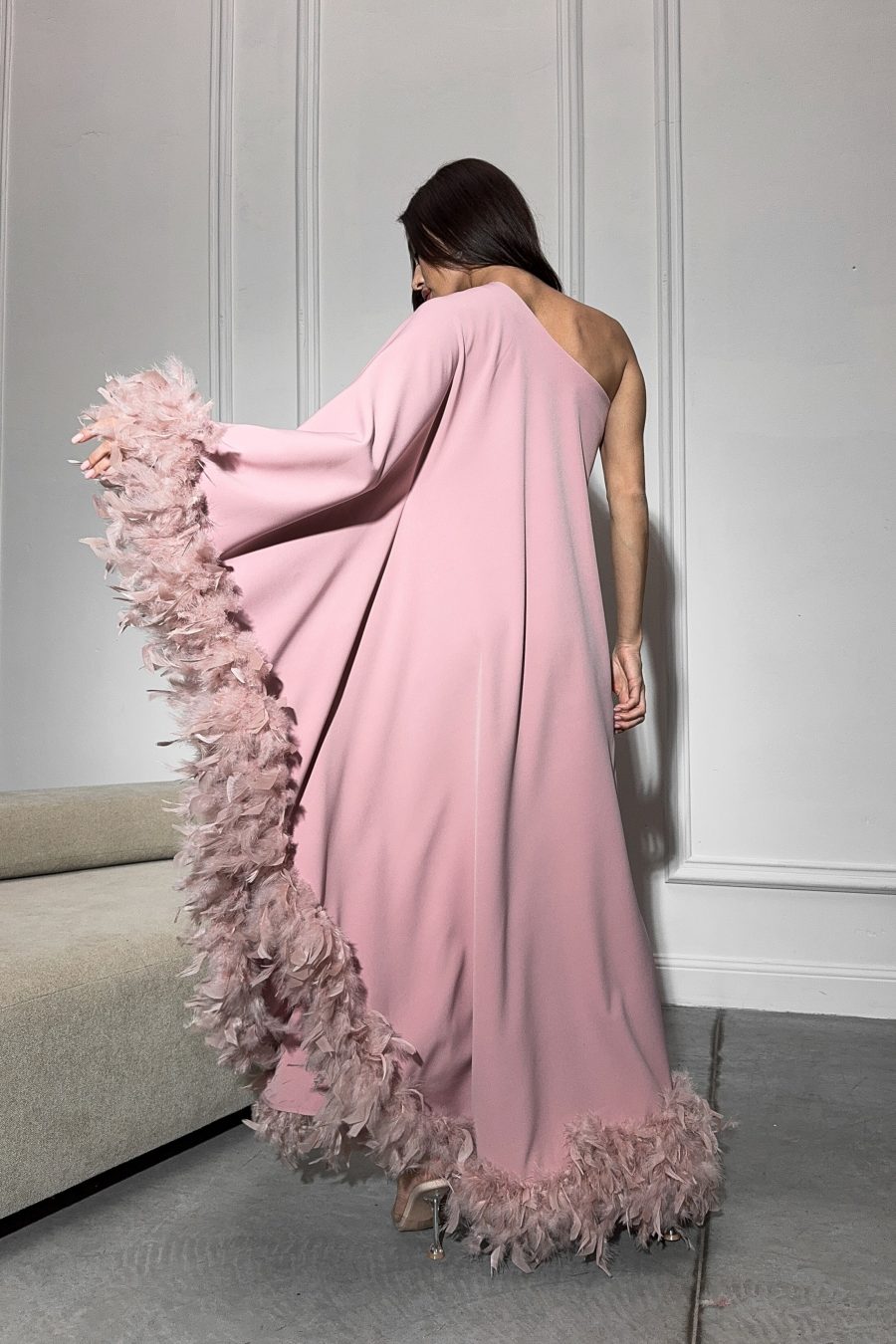 Long dress with a loose silhouette on one shoulder, with feathers