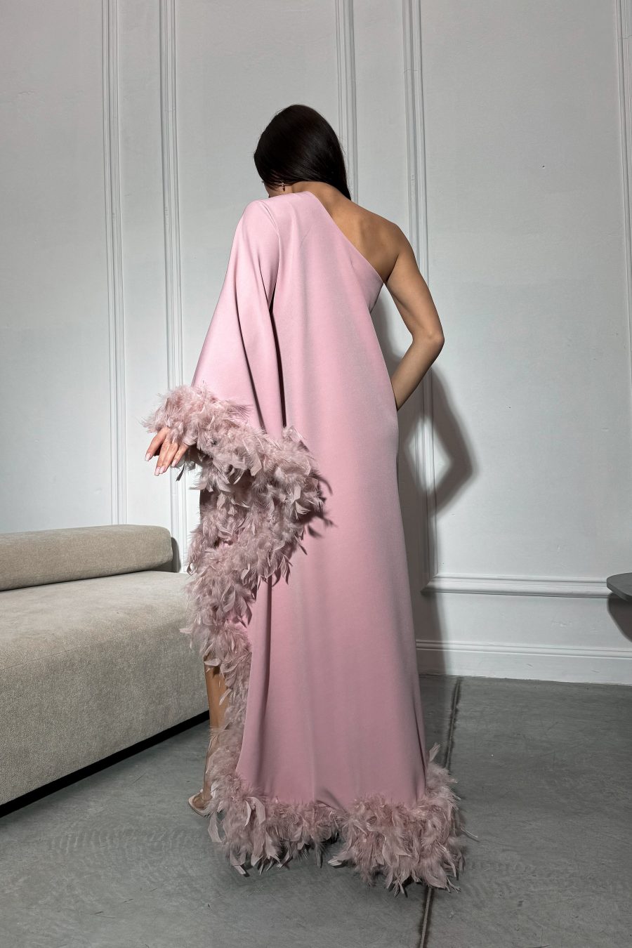 Long dress with a loose silhouette on one shoulder, with feathers